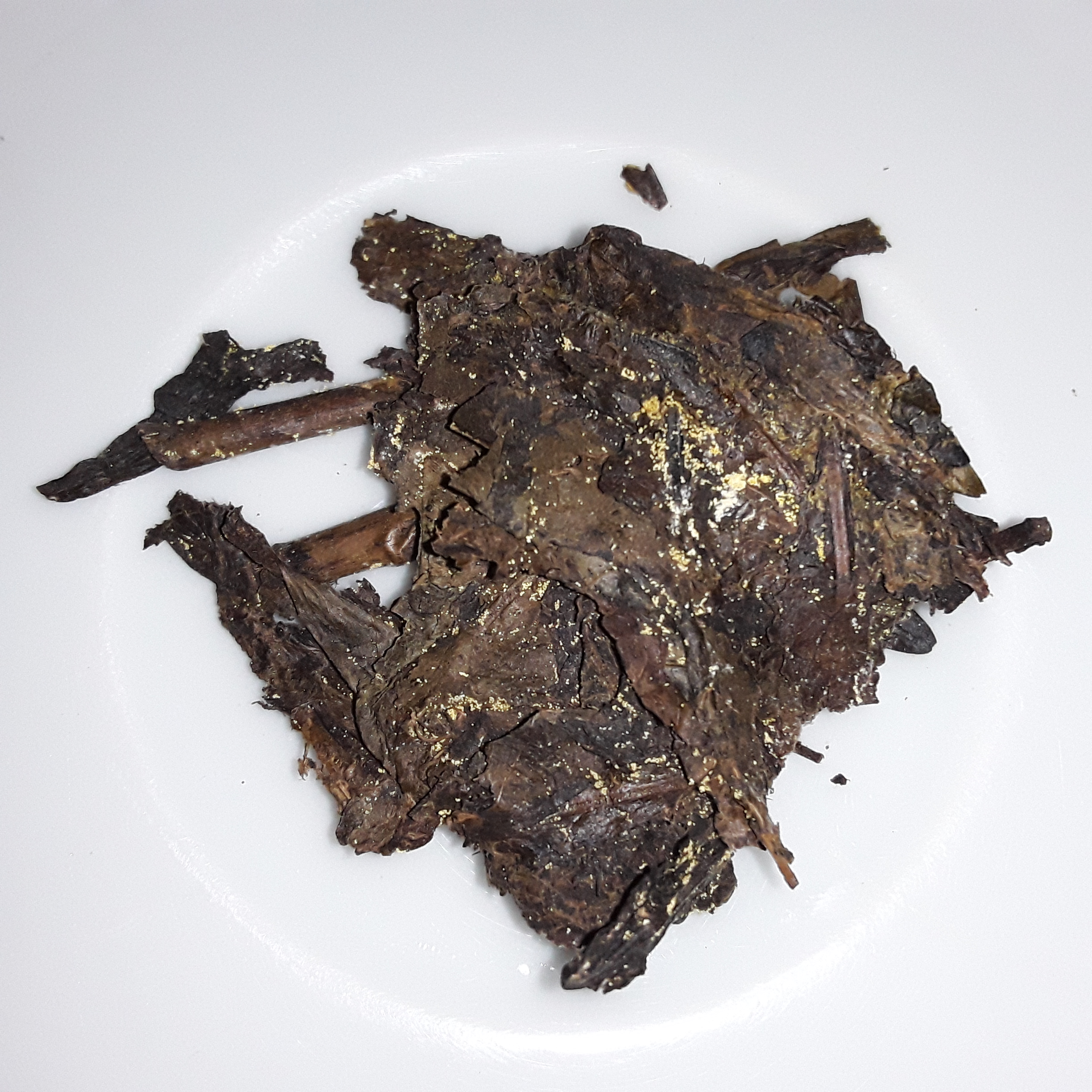 安化茯砖茶干茶实物，表面密布金黄色冠突散囊菌菌落